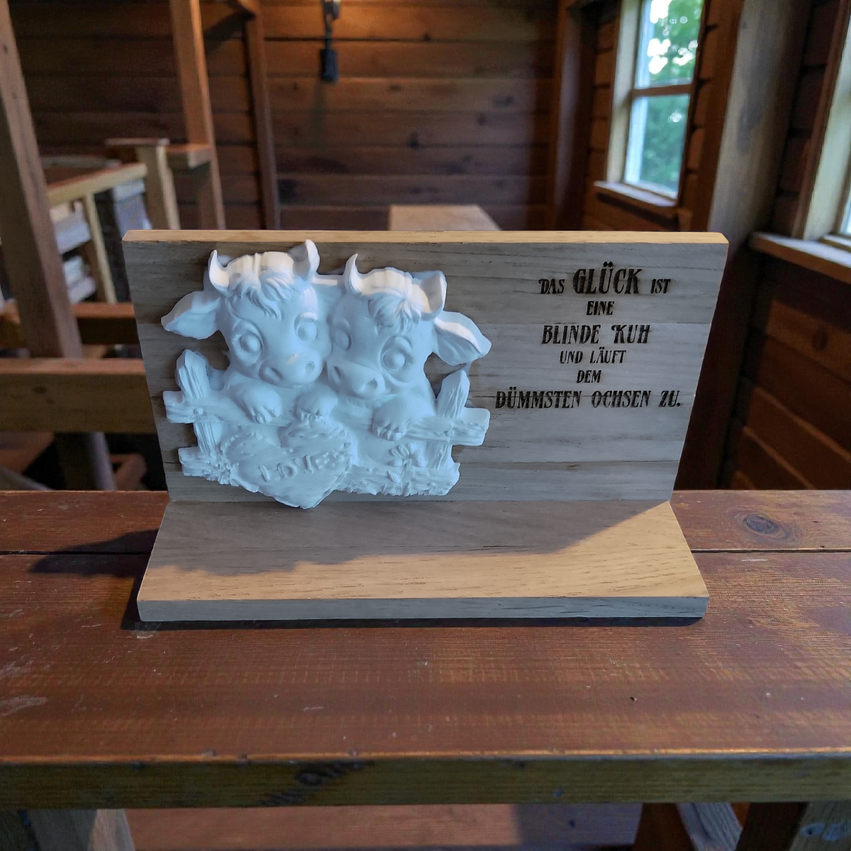 verliebtes Kuhpaar aus Keramikguss auf Holzrahmen