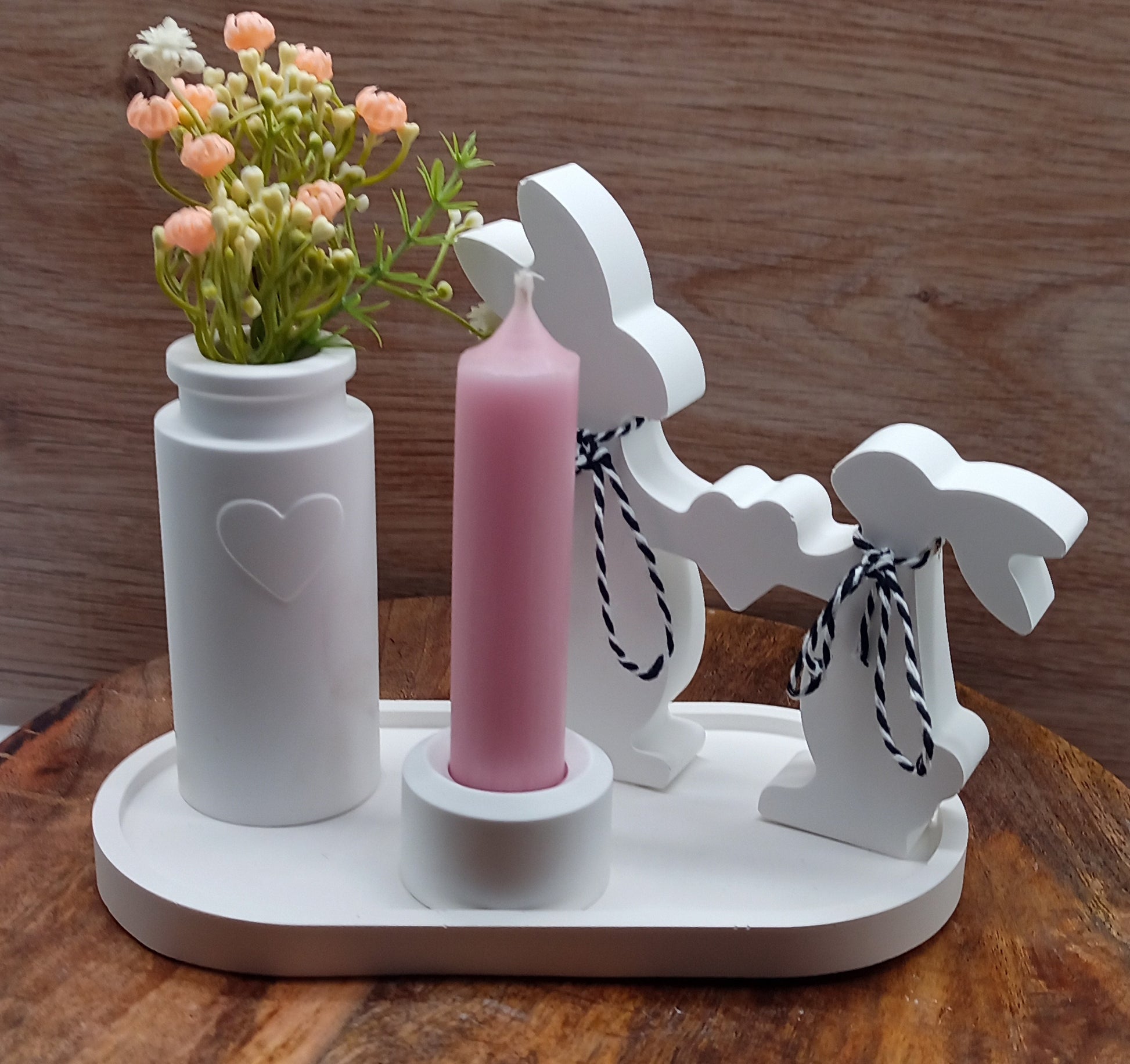 Osterhasen mit Blumen und Kerze auf Tablett 